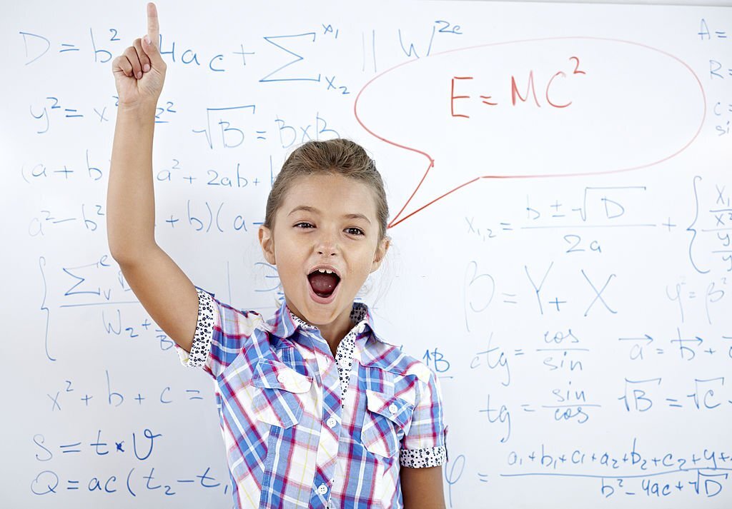 Little girl against whiteboard solving a difficult mathematical task